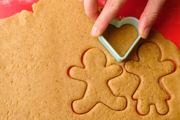 Cutting gingerbread shapes. Family or love couple concept from dough for St. Valentines Day. 