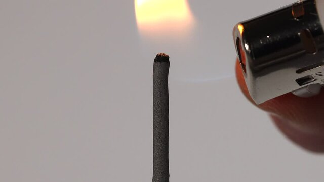 Nahaufnahme einer brennenden Wunderkerze. Makroaufnahme von Funken, die von einer Wunderkerze wegfliegen. Silvester allein Covid-19. Strukturmuster einer Wuderkerz. ein Feuerzeug befeuert einen Funker