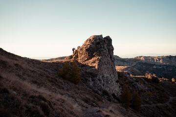 Fototapeta premium Man in the mountain at sunset. Guy practicing trekking