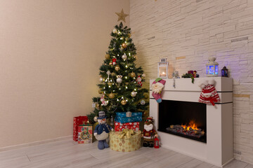 Decorated Christmas tree, gifts in boxes, a Santa Claus statuette, a burning fireplace. New Year, Christmas. Selective focus.