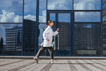 Obraz na płótnie Canvas concerned female doctor quickly runs down the street .