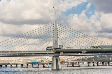 A modern The Golden Horn Metro Bridge  across the Golden Horn at Bosphorus strait in Istanbul, Turkey against cloudy sky