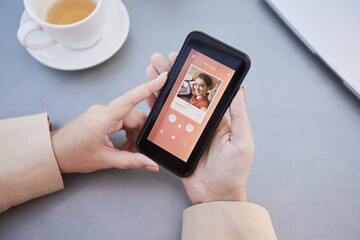 Close-up of woman loading her photo on mobile phone and using dating app online