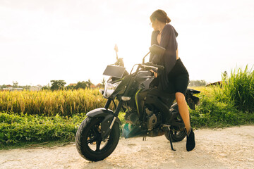 Plakat Unrecognizable woman resting on motorbike