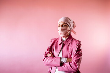 Woman with headscarf and pink mask, cancer patient.