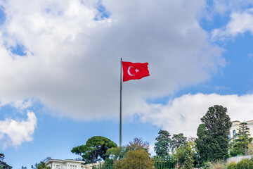 Turkish national flag and modern buildings along the Bosphorus strait in Istanbul Turkey from ferry on a sunny day with background cloudy sky
