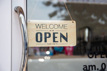 Open sign wooden broad through the glass of window at coffee shop