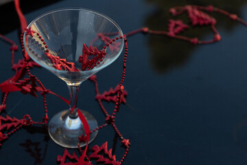 beautiful martini glass decorated with a Christmas red garland with trees and stars on a dark background. High quality photo