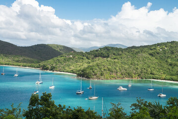 St. Thomas island with sailboats in the bay and mountains in the background.