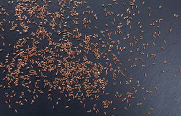 flaxseed scattered on a dark stone slab