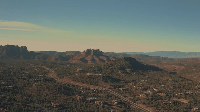 Aerial Drone View of residential areas and roads in Sedona and Oak Creek Canyon in Arizona on a bright and sunny fall day showing unique red rock formations and landscapes 