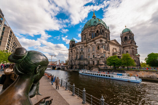 Three Girls One Boy bronze statue (Drei M&auml;dchen und ein Knabe) overlooking Beliner Dom in Museuminsel across Sprea River in Berlin city, Germany