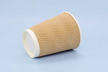 an empty beige coffee cup lies on a blue background