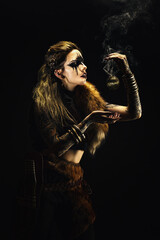 Portrait of a young viking shaman holding a ball of incense in his hands