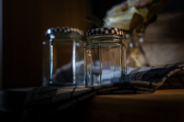 Still life of two glass jars on a shelf.