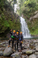 A group of young happy rock climbers in helmets and climbing equipment preparing for an adventure