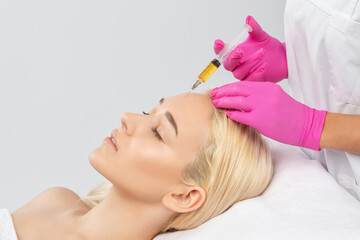 Cosmetologist does prp therapy on the face of a beautiful woman in a beauty salon. Cosmetology...