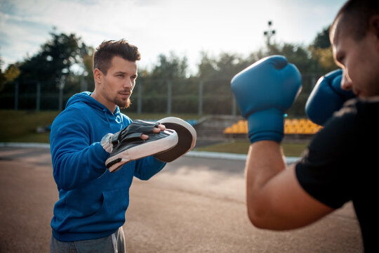sport man boxing and exercising in boxing gloves with personal fitness trainer