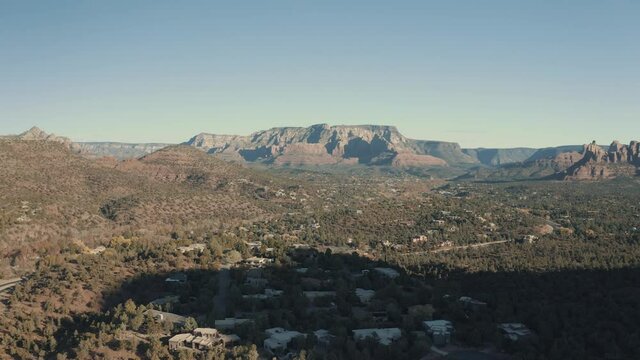 Aerial Drone View of residential areas and roads in Sedona and Oak Creek Canyon in Arizona on a bright and sunny fall day showing unique red rock formations and landscapes 