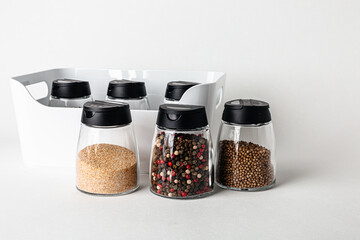 Salt and pepper grinders. Dried whole seed of black pepper and white coarse sea salt isolated on a...