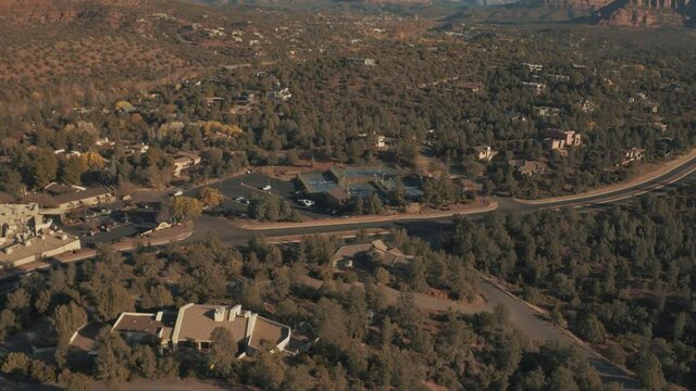 Aerial Drone View of residential areas and roads in Sedona and Oak Creek Canyon in Arizona on a bright and sunny fall day showing unique red rock formations and landscapes 