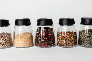 Salt and pepper grinders. Dried whole seed of black pepper and white coarse sea salt isolated on a...