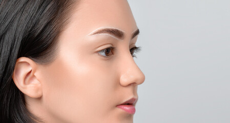 Obraz premium Permanent make-up for eyebrows of beautiful woman with thick brows in beauty salon. Closeup beautician doing tattooing eyebrow. Professional makeup and cosmetology skin care.