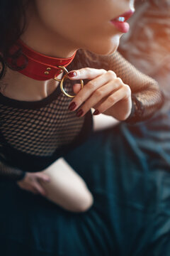 close up of sensual female with red lips and leather bondage collar choker
