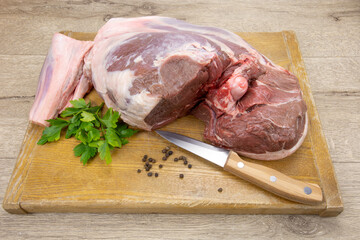 gigot d'agneau cru sur une planche à découper