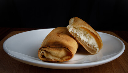Pancakes stuffed with cottage cheese on a white plate
