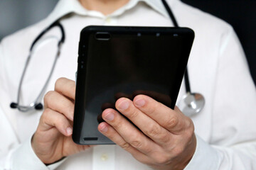 Man doctor with a tablet PC in hands. Work of medical staff