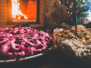 Festive salads on the background of the fireplace. Olivier and herring under a fur coat close up