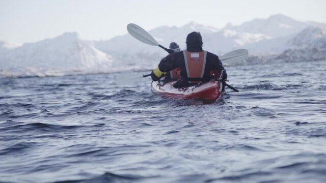 Couple canoeing in Arctic ocean