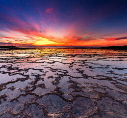 beautiful sunset over the ocean with rocky beach and tidal pools in the foreground