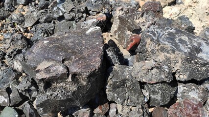 black unusual stone background. dark background from crushed slag, close-up.