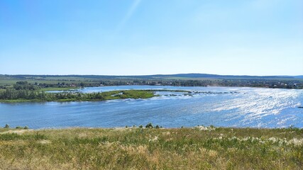beautiful view from the hill to the large lake and the village below. sunny and clear sky