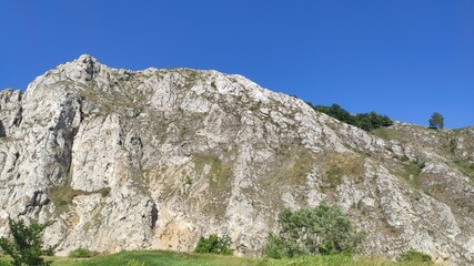Bottom view of a beautiful mountain. At the foot of the mountain. Blue sky background