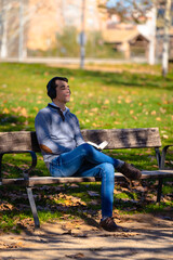 Man sitting in a park reading a book