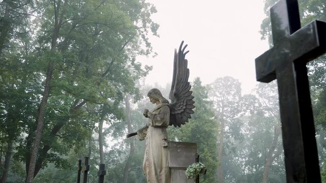  An old Angel statue at the Bernardine XIX century cemetery on a foggy day. 