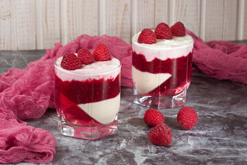 White delicious yogurt dessert with raspberry berries, jam and raspberry jelly. Healthy Breakfast, light snack. The concept of healthy eating.