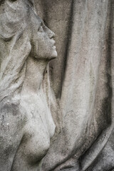 Fototapeta na wymiar statue of a woman on an old tombstone