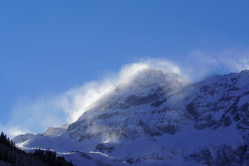 strong south wind in the alps in winter on a sunny day in the national park hohe tauern in austria