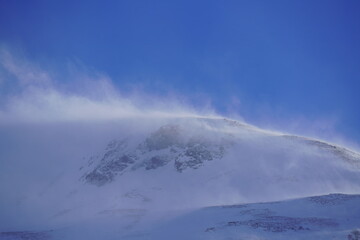 strong south wind in the alps in winter on a sunny day in the national park hohe tauern in austria