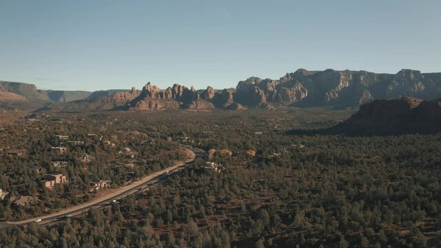 Aerial Drone View of residential areas and roads in Sedona and Oak Creek Canyon in Arizona on a bright and sunny fall day showing unique red rock formations and landscapes 