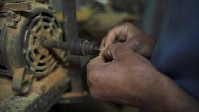 Woodworker's Hands Drilling Holes Into A Tiny Wood Cube With A Drilling Machine - Essaouira, Morocco - close up