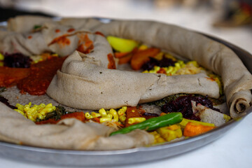 Ethiopian traditional dish, sour pancake with hot pepper sauce and other vegetables
