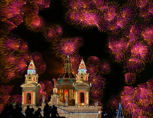 Colorful amazing fireworks in Luqa, Malta with house lights in the background,explode, dark sky background and house light. Malta.Maltese fireworks.Pyrotechnics show