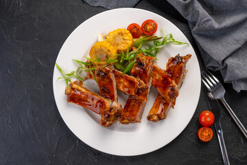 barbecue beef ribs with vegetable garnish on a white plate. Grilled ribs