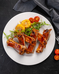 barbecue beef ribs with vegetable garnish on a white plate. Grilled ribs