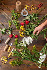 Fototapeta na wymiar Hands of a woman arranging a bouquet of flowers